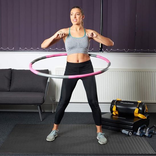 Femme faisant exercice de renforcement abdominal Hula hoop cerceau 
