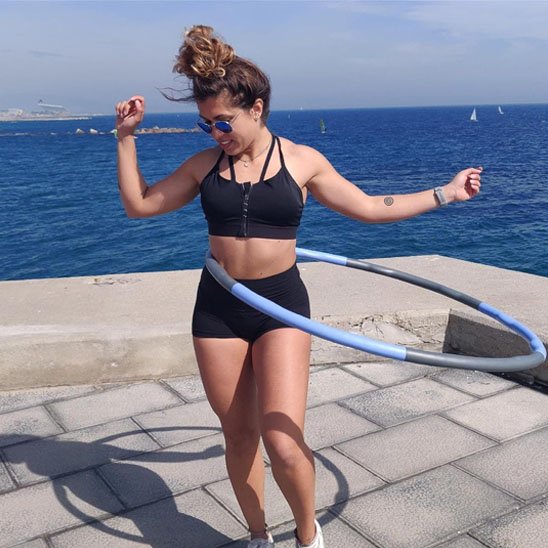 Femme qui fait exercice à la taille avec Hula hoop cerceau polyvalent